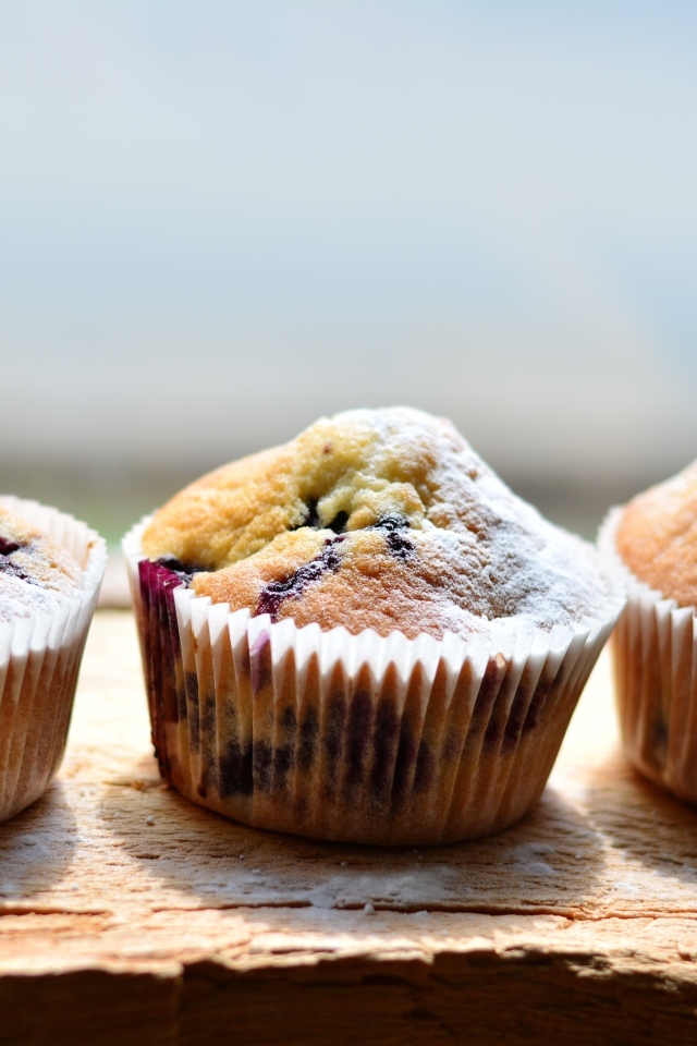 Три вкусных сладких кекса с сахарной пудрой на столе