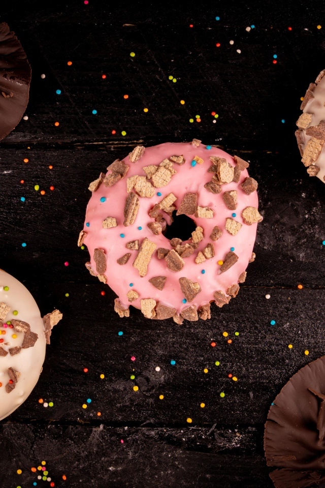 Три сладких пончика на черном столе