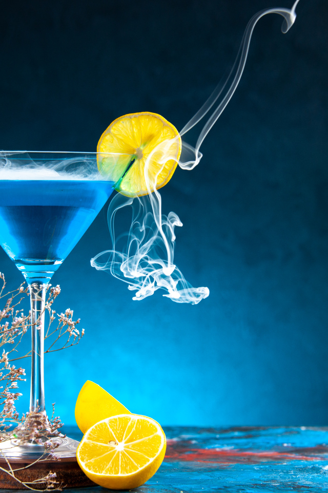 Голубой коктейль с лимоном на столе