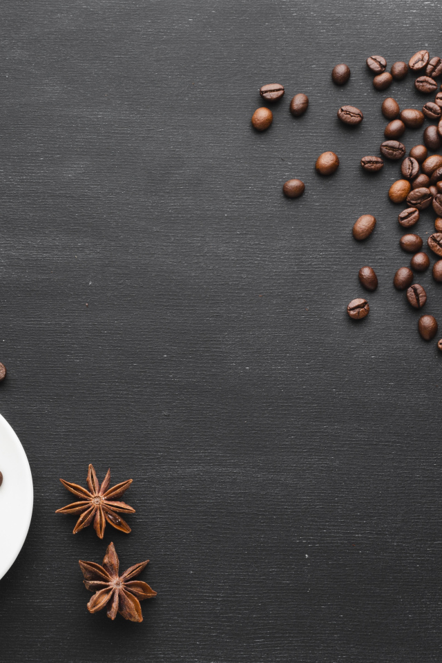 Чашка кофе на черном столе с зернами