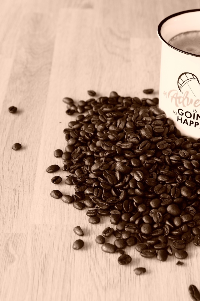 Чашка кофе на деревянном столе с кофейными зернами