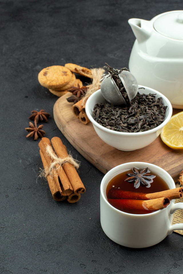 Вкусный чай на столе с лимоном и пряностями