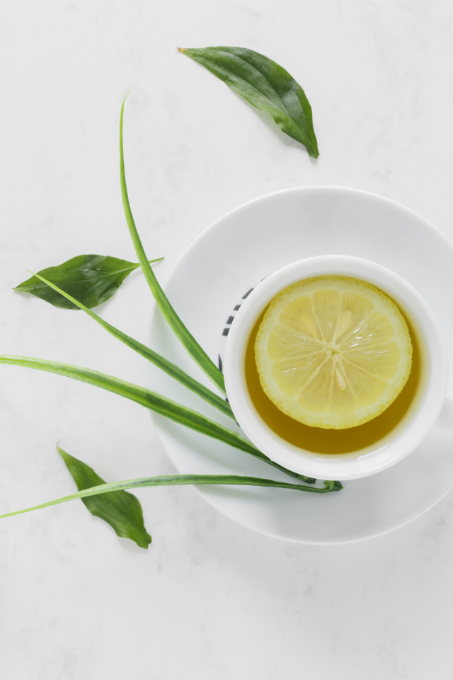 Чай в чашке на столе с кислым лимоном