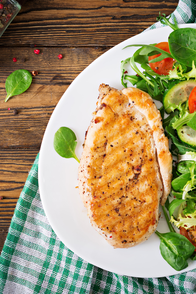 Жареная куриная грудка на тарелке с салатом