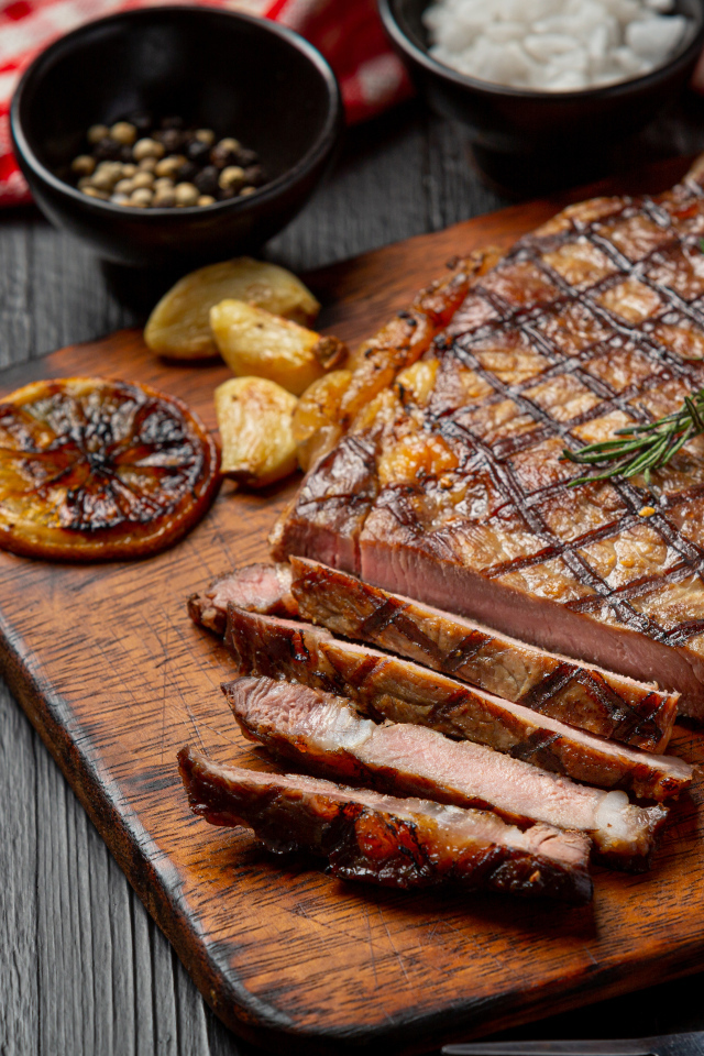 Кусок мясо барбекю на доске с овощами