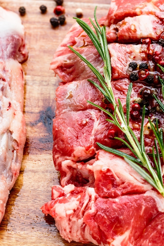 Кусок свежего мяса с перцем и розмарином