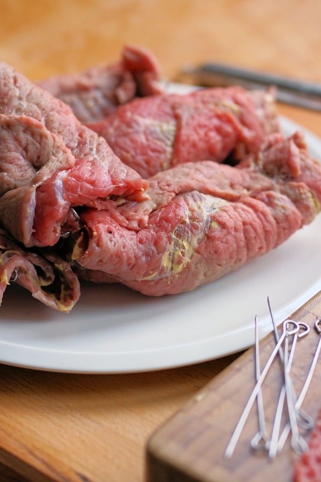 Рулетики из свинины на большой белой тарелке