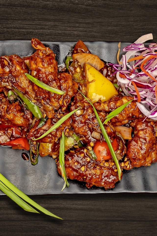 Острые куриные крылышки с салатом на тарелке