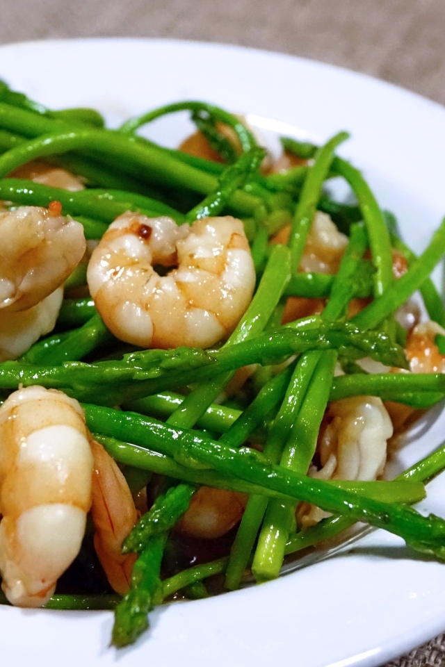 Спаржа с креветками в белой тарелке