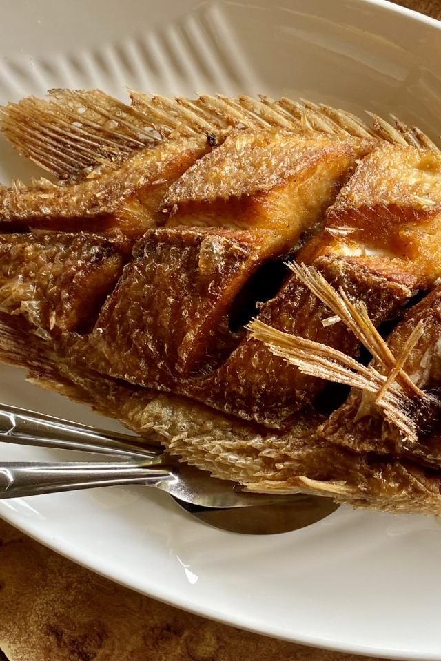 Запеченный карп на белой тарелке