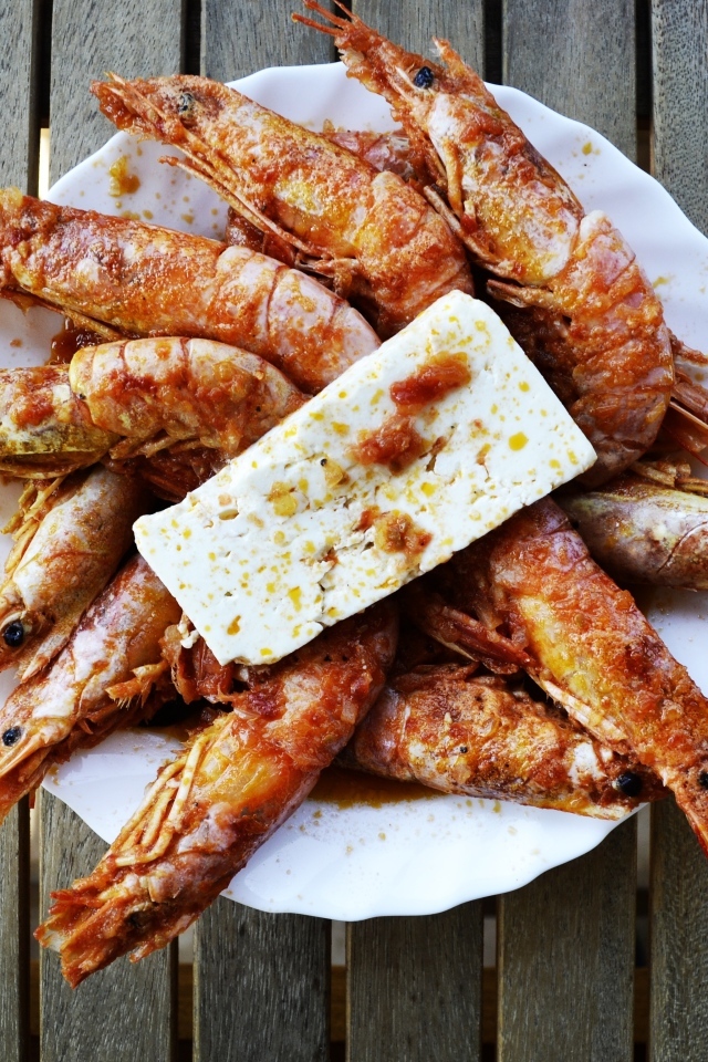 Жареные креветки на тарелке с сыром