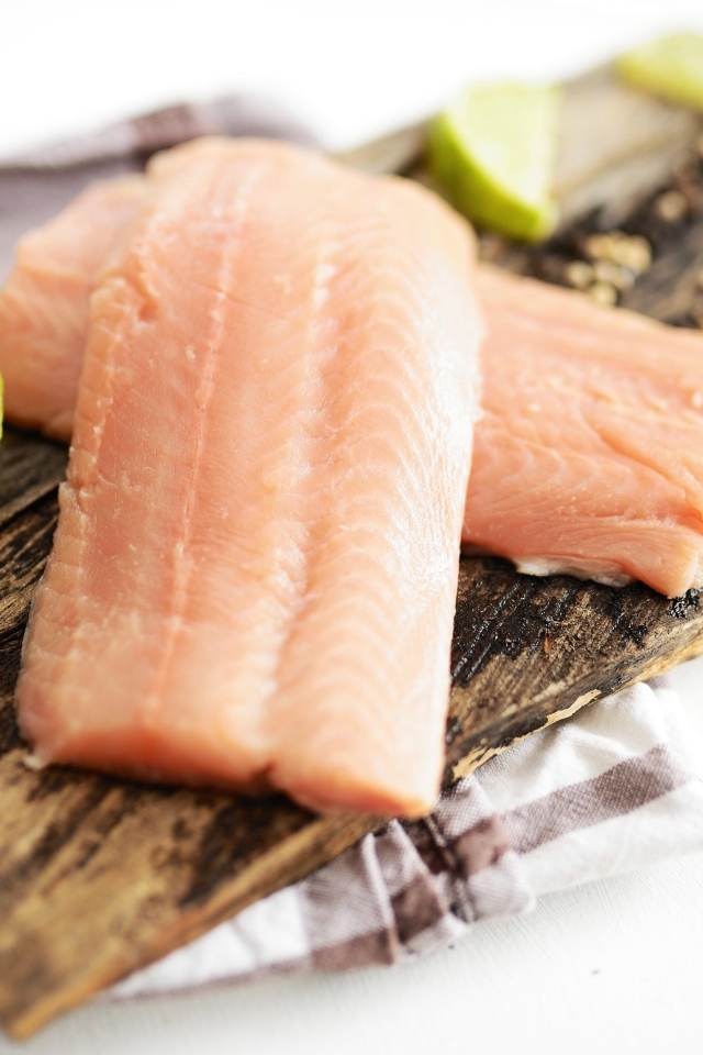 Кусочки рыбы на столе с лаймом