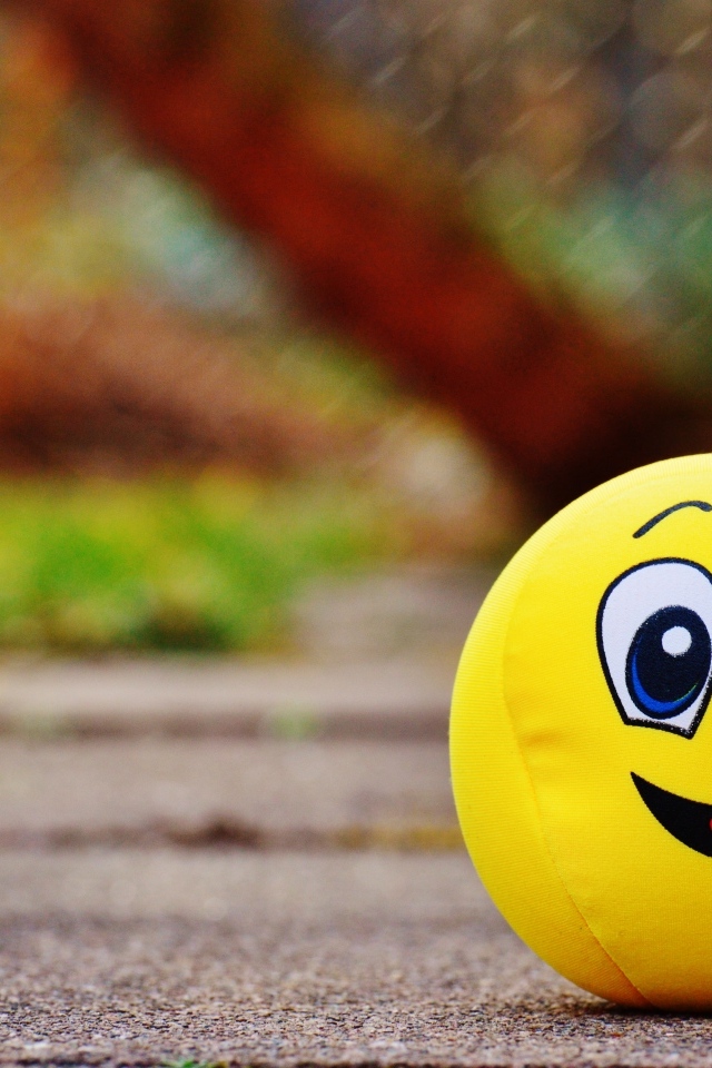 Желтый мягкий мяч смайл на дороге
