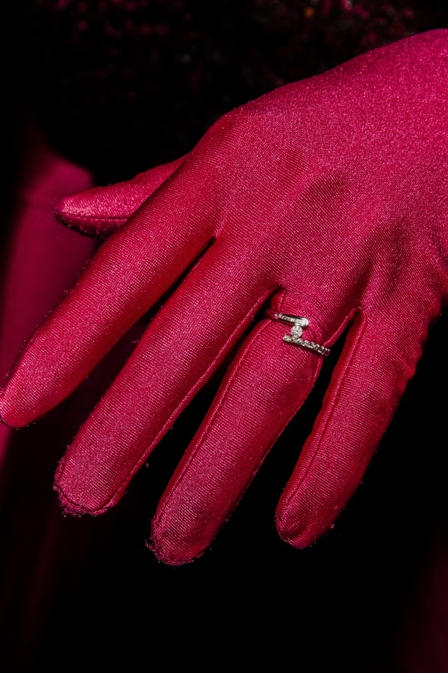 Женская рука с красной перчаткой и кольцом