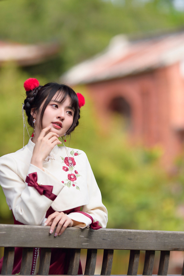 Девушка азиатка в народном костюме стоит у перил