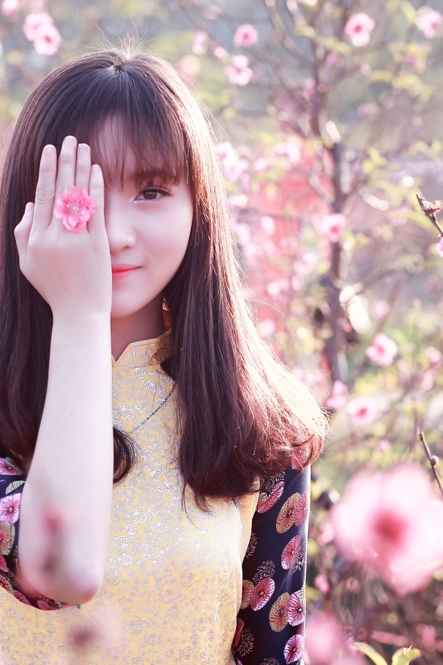 Девушка азиатка закрыла глаз рукой