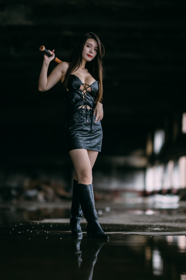 Азиатка в черном кожаном костюме с битой в руках