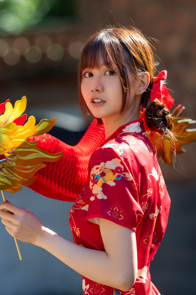 Азиатка в красном платье с бумажным драконом