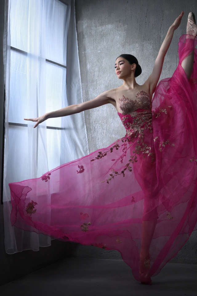 Девушка балерина в красивом розовом платье у окна