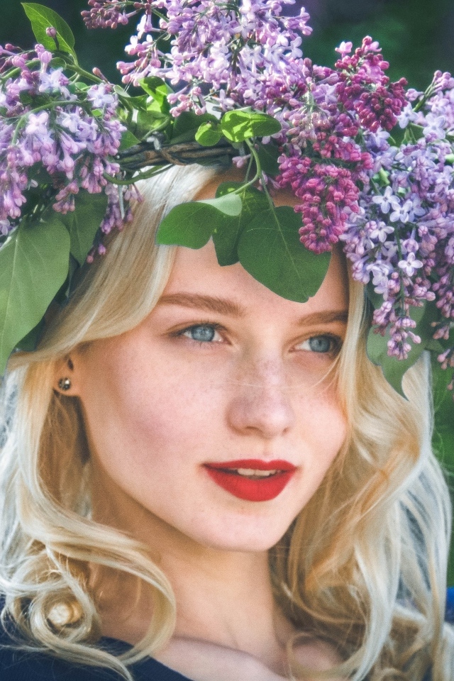 Красивая голубоглазая девушка с венком из сирени на голове