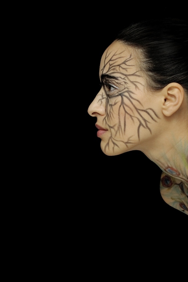 Красивая девушка с рисунком на теле на черном фоне