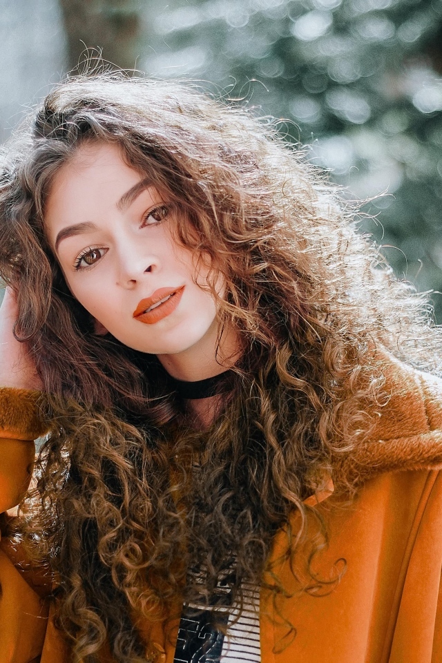 Красивая девушка с кудрявыми волосами и карими глазами