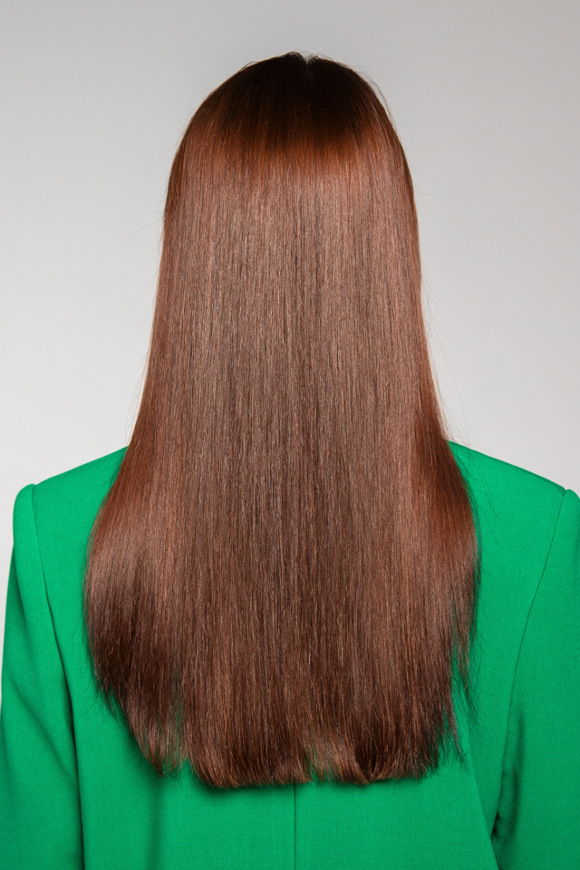 Красивые волосы девушки в зеленом пиджаке