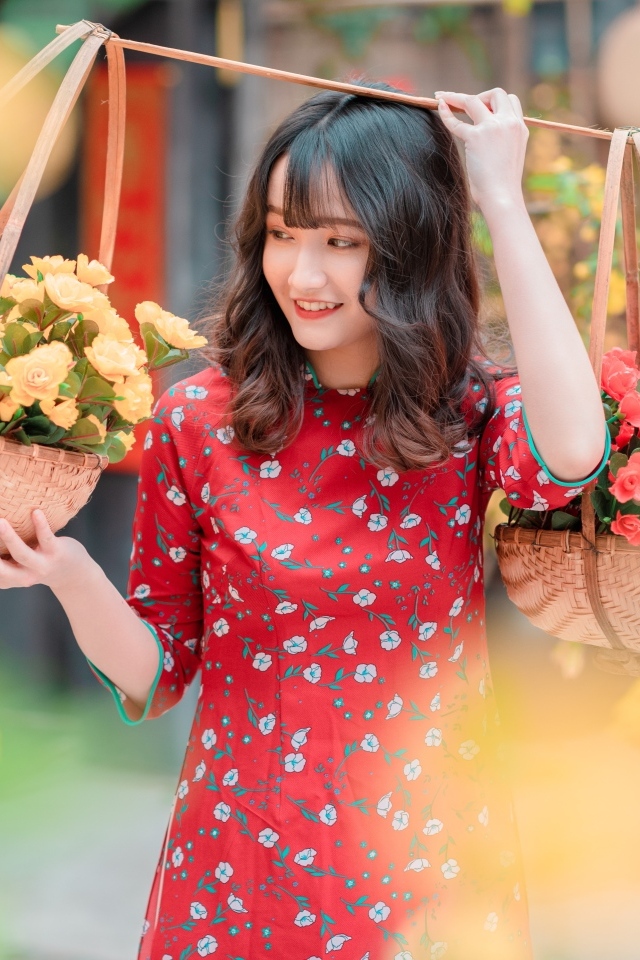 Милая девушка азиатка с цветами в красном платье