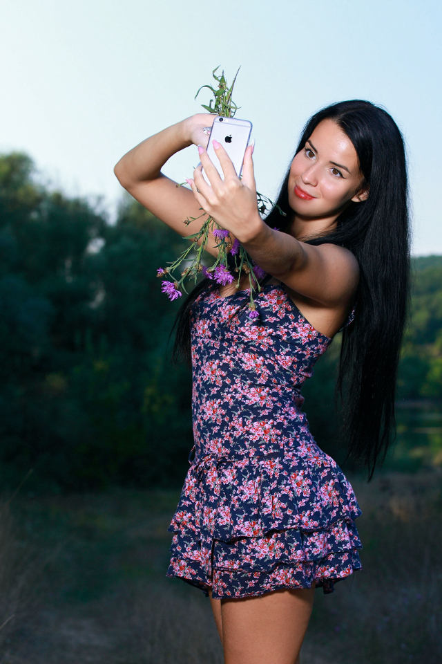 Милая брюнетка в коротком платье делает фото