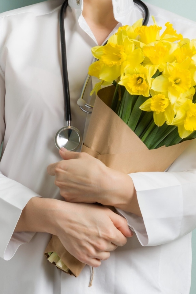 Доктор в букетом нарциссов  в руках