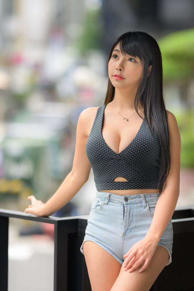 Мечтательная девушка азиатка в коротких шортах