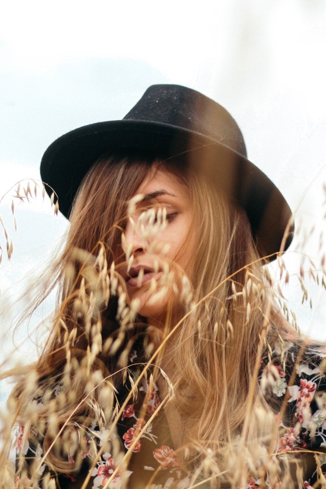 Девушка в черной шляпе в траве