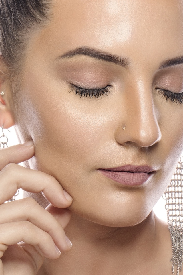 Девушка с закрытым глазами на белом фоне