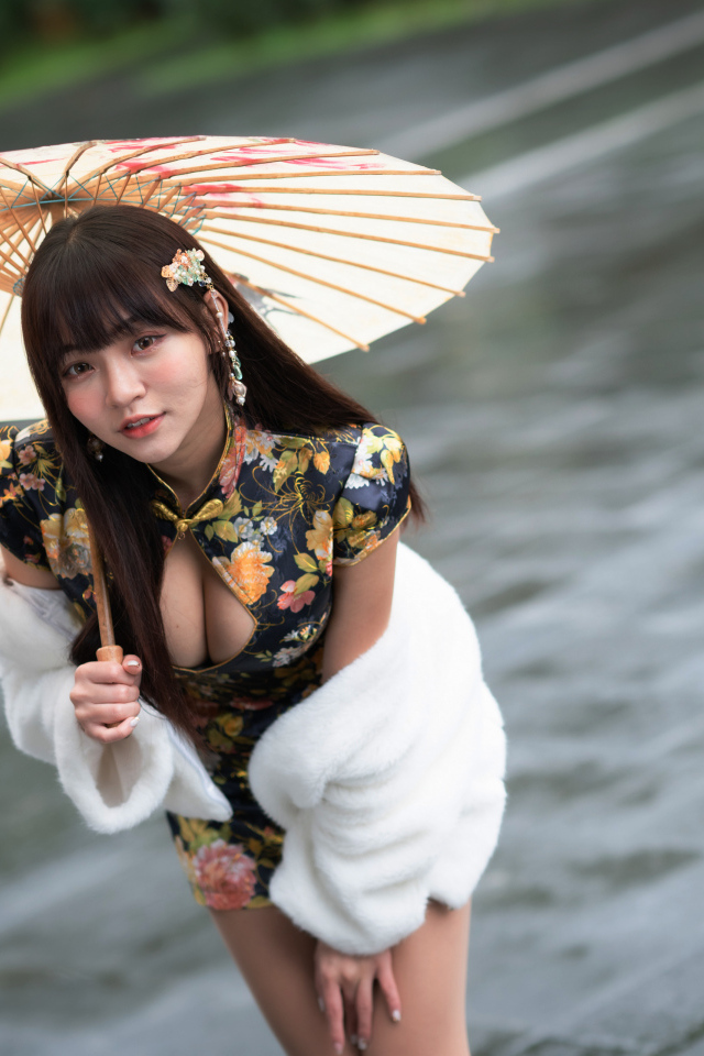 Настоящая азиатка стоит под зонтом