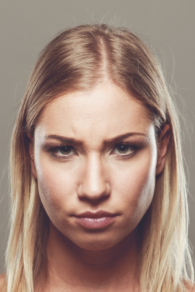 Серьезная девушка с короткой стрижкой на сером фоне