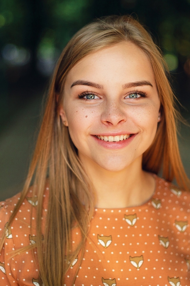 Улыбающаяся милая зеленоглазая девушка