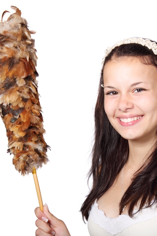 Улыбающаяся девушка убирается в комнате