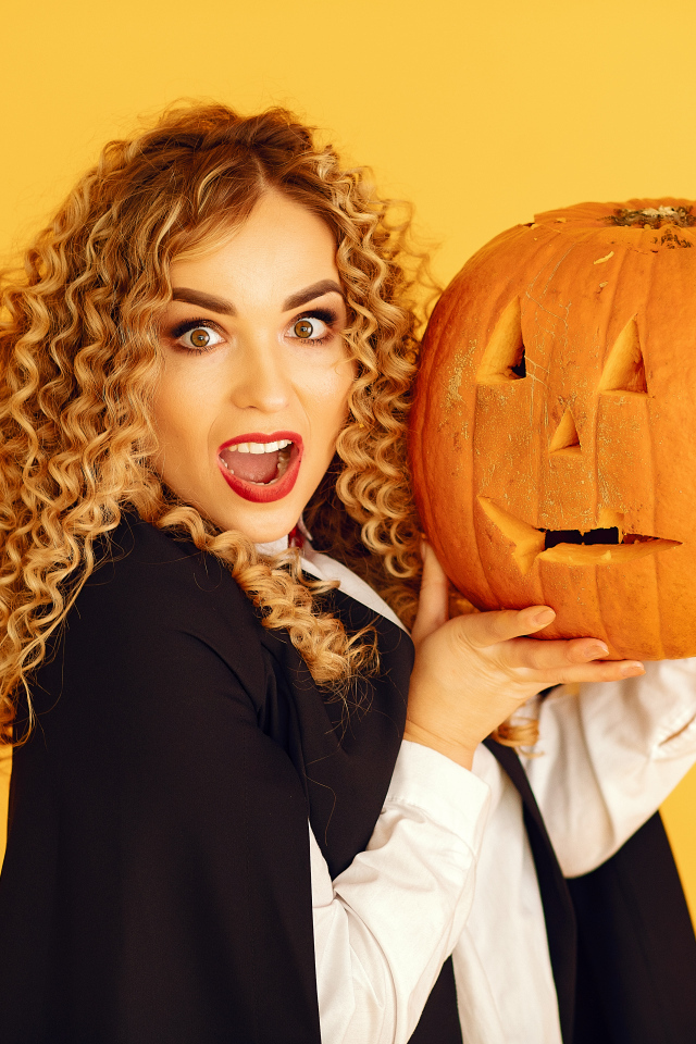 Удивленная девушка с тыквой на Хэллоуин