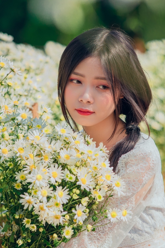 Нежная девушка азиатка с цветами ромашки