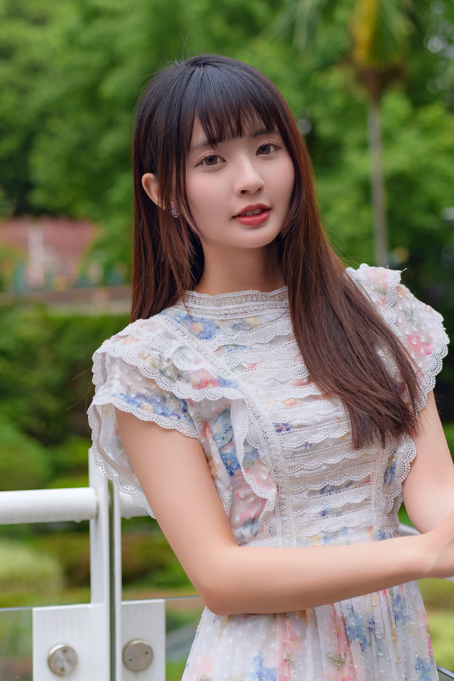 Нежный взгляд молодой длинноволосой азиатки в платье