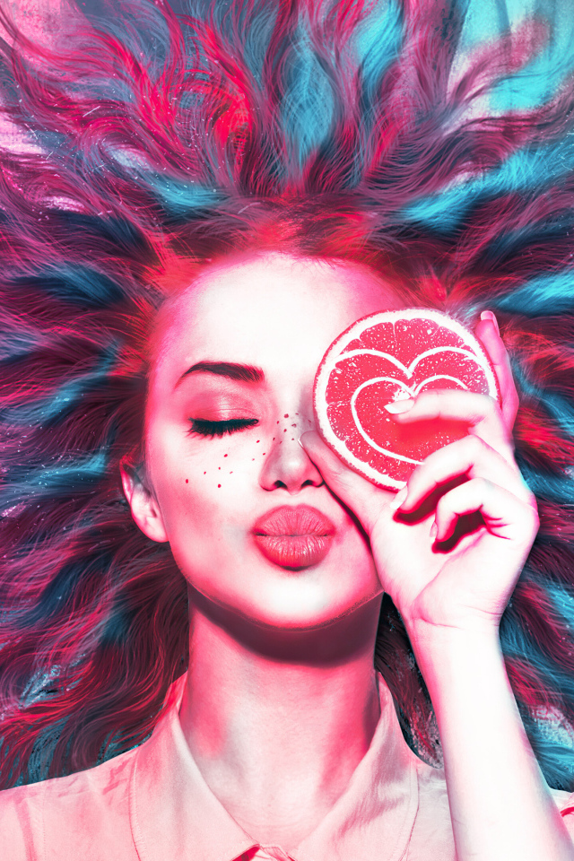 Девушка закрыла глаз кружочком апельсина