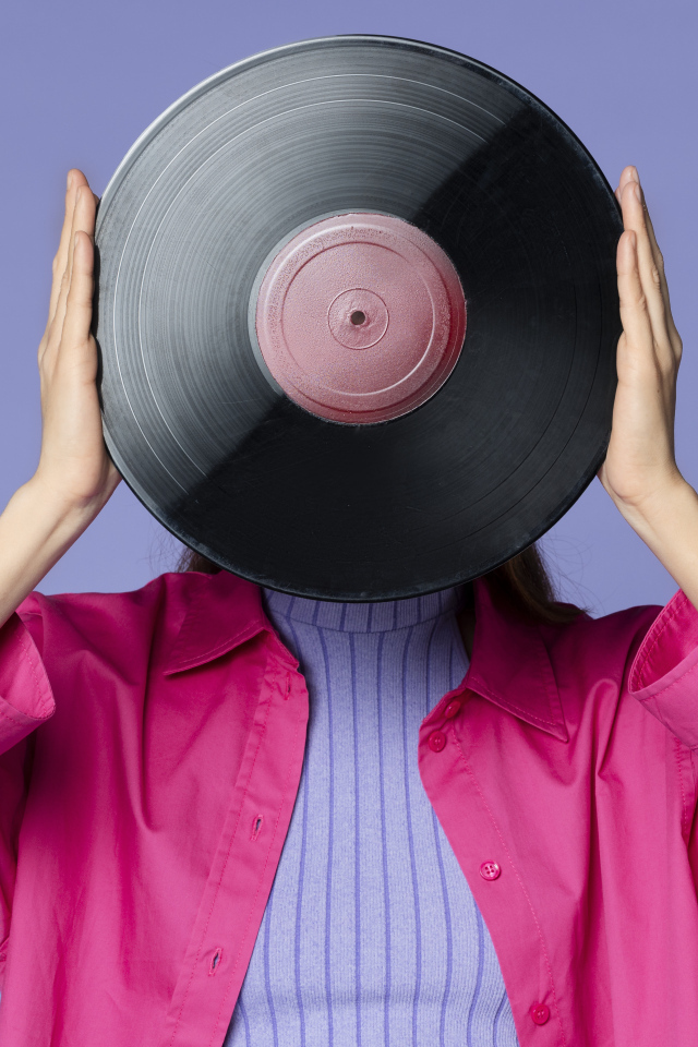 Девушка закрыла лицо пластинкой 