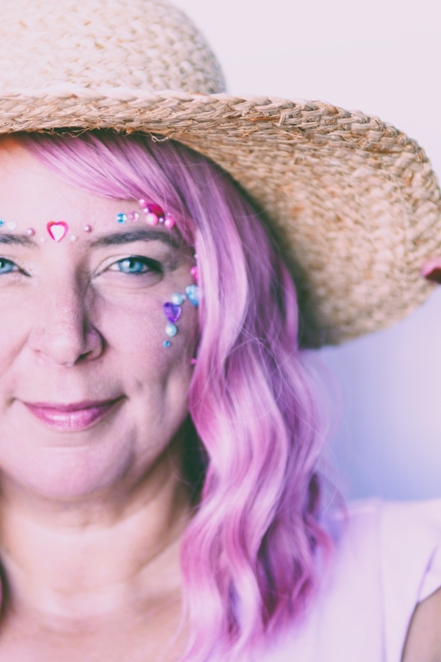 Женщина в шляпе с розовыми волосами