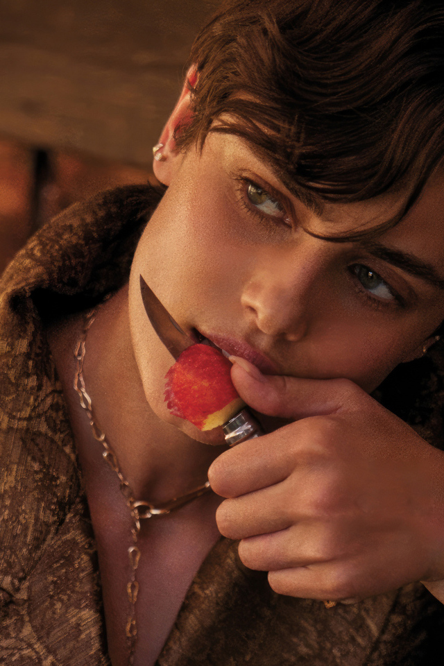 Модель Тейлор Хилл с ножом ест яблоко