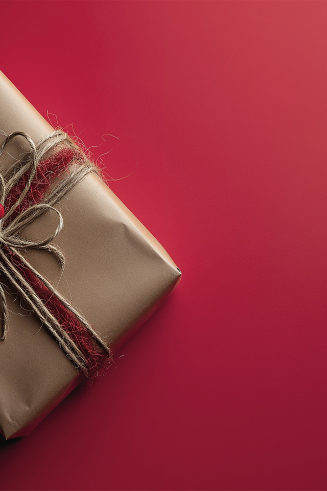Подарок в бумаге на красном фоне