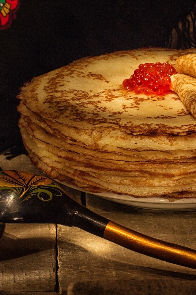 Тонкие блинчики с икрой и деревянной ложкой на Масленицу