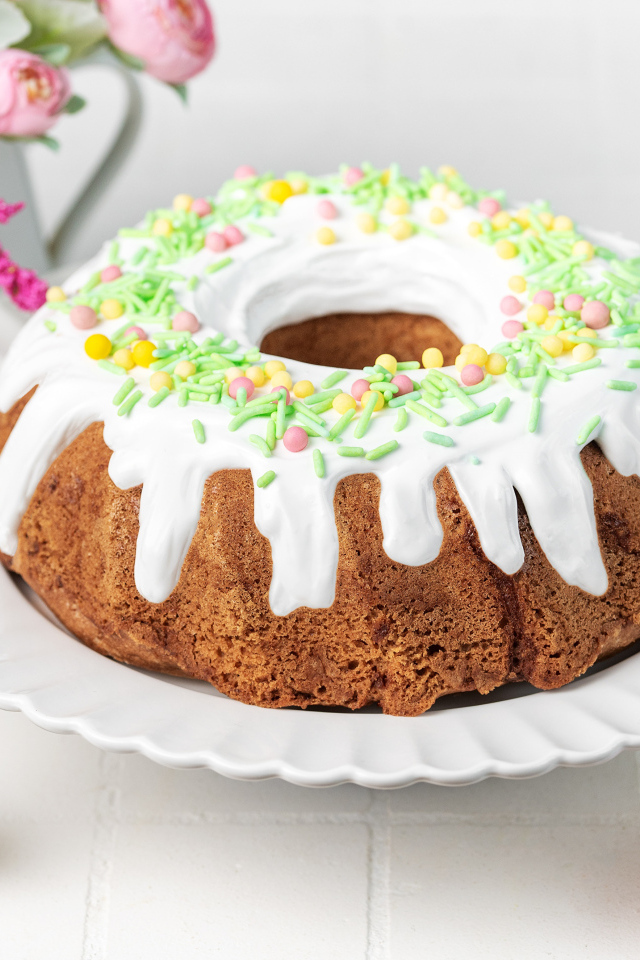 Сладкий пасхальный кулич с яйцами и цветами на столе