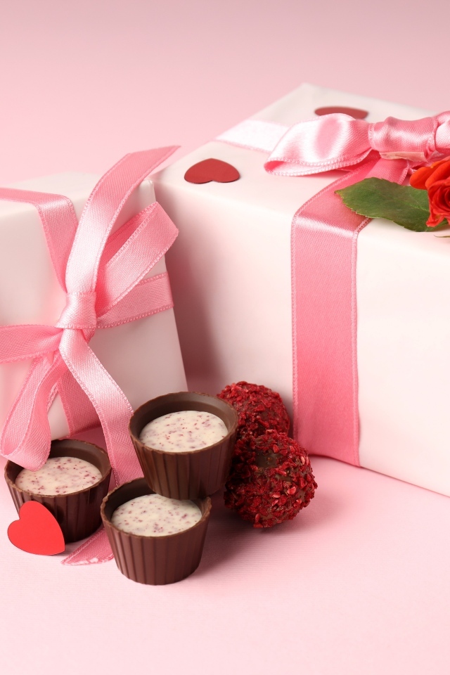 Два подарка с конфетами на розовом фоне на День Святого Валентина