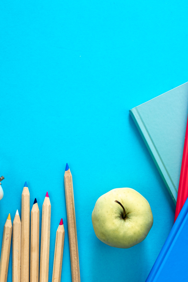 Книги на столе с глобусом, карандашами и будильником