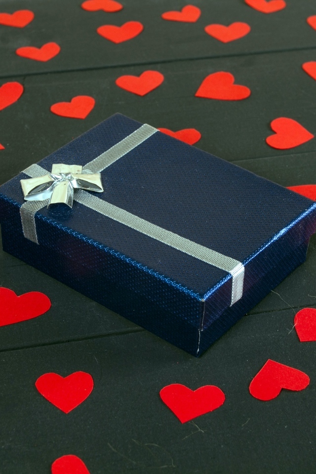 Черная коробка с красными сердечками на столе